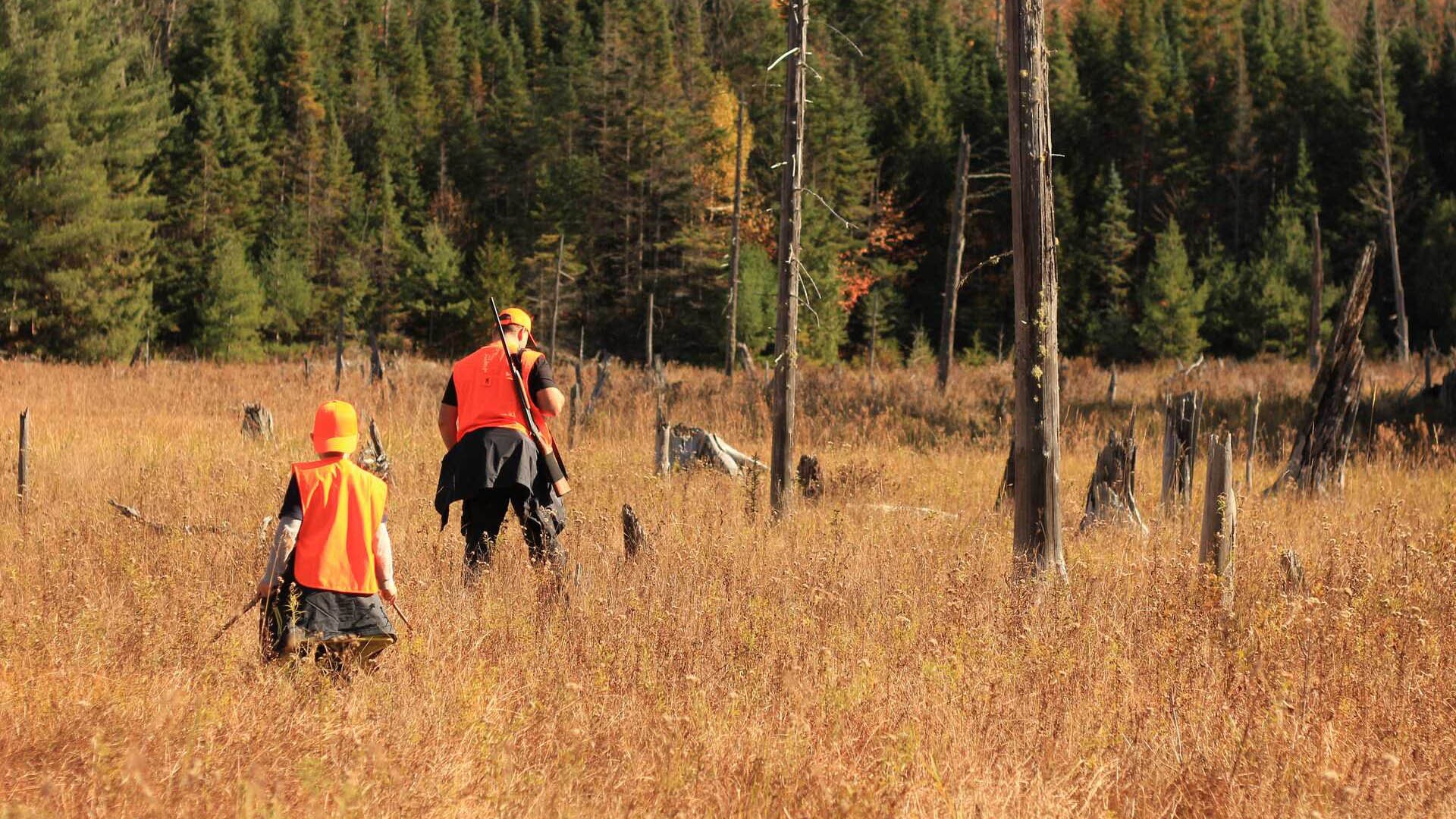 Father and son hunting in field